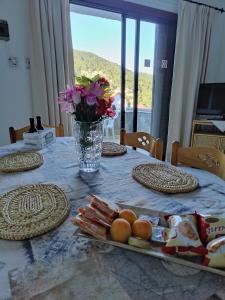 a table with plates of food and a vase of flowers at Stylineo Platres in Platres