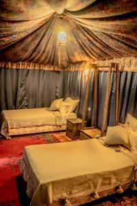 a bedroom with two beds in a tent at Ouednoujoum Ecolodge & Spa in Ouarzazate