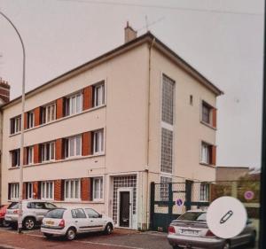 a white building with cars parked in front of it at Laila in Creil