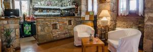 een bar met 2 witte stoelen en een tafel bij Villa Calussovo in Ripenda Kras