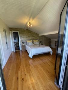 1 dormitorio con 1 cama y suelo de madera en Le chalet des Pesettes, en Thorens-Glières