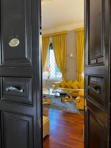 an open door to a living room with yellow curtains at Holiday House Belle Arti - NEL CUORE DI ROMA in Rome