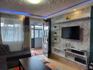 a living room with a television on a stone wall at Parkview apartments in Nakuru