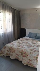 um quarto com uma cama grande e um cobertor floral em Cottage Teremok 7 people em Ureki