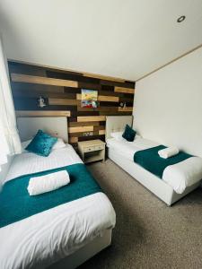 2 camas en una habitación de hotel en Hedgerow Lodge with Hot Tub, en Malton