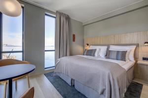 a bedroom with a large bed and a large window at Quality Hotel Harstad in Harstad