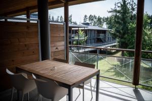 a wooden table and chairs on a balcony with a view at Domaine de Cicé-Blossac, Resort Spa & Golf in Bruz