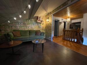 a living room with a green couch and a table at Le chalet des Pesettes in Thorens-Glières