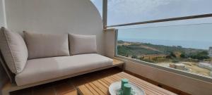 Sofá blanco en una habitación con ventana grande en Small Oasis in Costa del sol, en Manilva