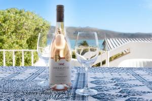 a bottle of wine sitting on a table with two glasses at 7onmeeu in Langebaan