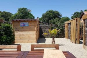 a garden with a wooden shed and two benches at Le Chai de l'Océan - Studio Avec jardin et terrasse - plage 300 m in Soulac-sur-Mer