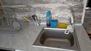 um lavatório de cozinha com uma torneira e um lavatório em Cottage Teremok 7 people em Ureki
