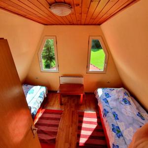Habitación pequeña con 2 camas y banco. en Doi Frati, en Topliţa