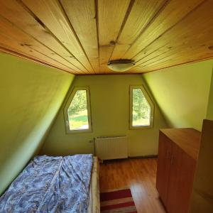 Schlafzimmer mit einem Bett und einer Decke mit Fenstern in der Unterkunft Doi Frati in Topliţa