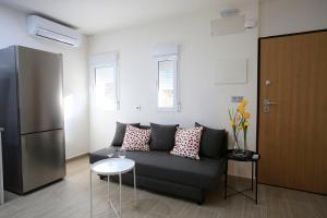 een woonkamer met een bank en een koelkast bij Apartamentos Amanecer Centro in Murcia