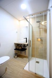 uma casa de banho com um chuveiro, um WC e um lavatório. em Apartamentos Amanecer Centro em Múrcia