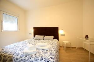 Un dormitorio con una cama con toallas. en Apartamentos Amanecer Centro, en Murcia
