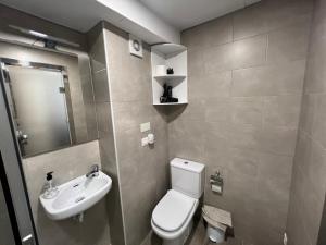 a bathroom with a white toilet and a sink at Apartment Lucena Park in Lucena