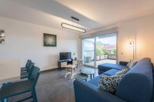 un soggiorno con divano blu e TV di Cabana & La Terrasse du Parmelan proche Annecy a Groisy