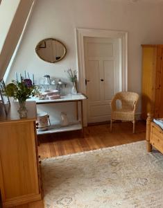 a living room with a table and a mirror at Private apartment in historic castle from 1608 with tenniscourt in Zeitlofs