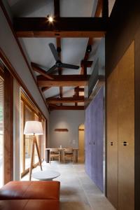 a living room with a ceiling fan and a table at 湯の里いけもり別館 天座 in Himi