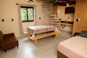 um quarto com uma cama, uma escada e uma mesa em Casa Florescer da Madeira em Pomerode