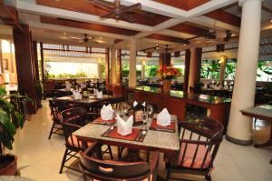 a restaurant with tables and chairs and a bar at Phuket Leelavadee Hua Ting Resort in Patong Beach
