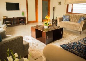 a living room with couches and a coffee table at Hype Holiday Homes in Karachi