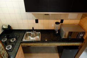 a small kitchen with a sink and a stove at Casa Florescer da Madeira in Pomerode