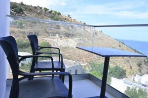 two chairs and a table on a balcony with the ocean at SEA & LAKE VIEW VILLA in (( Kalive Gjoka ))