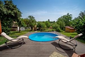 un patio avec deux chaises et une piscine dans l'établissement Rózsa Porta, à Zengővárkony