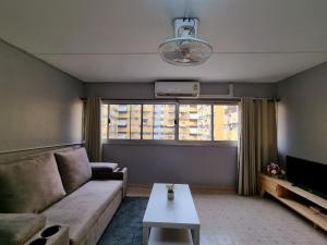 a living room with a couch and a large window at Banana Muji Home-C6 in Ban Song Hong