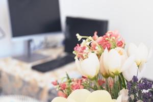 a vase of white and pink flowers on a counter at SEA & LAKE VIEW VILLA in (( Kalive Gjoka ))
