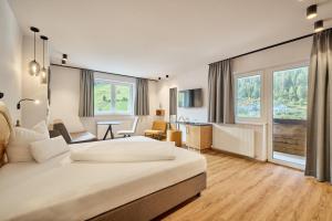 a hotel room with a large bed and a desk at Aktivhotel Feichtner Hof in Kaunertal