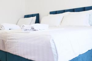 a large white bed with white sheets and pillows at SEA & LAKE VIEW VILLA in (( Kalive Gjoka ))