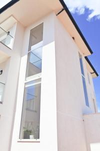 a white house with a large window at SEA & LAKE VIEW VILLA in (( Kalive Gjoka ))