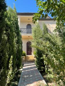 a house with a pathway leading to the front door at Green Garden Shuvelan in Baku