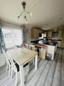 Una cocina con una mesa y sillas en una habitación. en Rowan Lodge with Hot Tub, en Malton