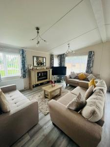 Una sala de estar con dos sofás y un televisor. en Rowan Lodge with Hot Tub, en Malton