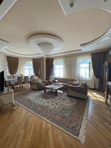 a living room with a couch and a table at Green Garden Shuvelan in Baku