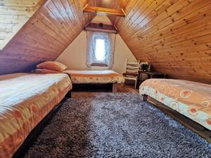 Schlafzimmer im Dachgeschoss mit 2 Betten und einem Fenster in der Unterkunft Wspaniały Zakątek in Sędziszowa
