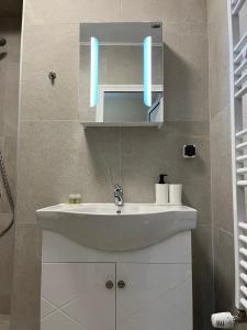 W łazience znajduje się biała umywalka i lustro. w obiekcie Movie flats w mieście Sofia