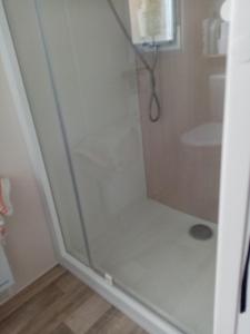 a shower with a glass door in a bathroom at camping les charmettes in Les Mathes