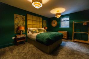 ein Schlafzimmer mit grünen Wänden und einem Bett mit grüner Tagesdecke in der Unterkunft Valentine Apartments presented by the V group in Blackpool