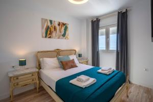 1 dormitorio con 1 cama con 2 toallas en ACQUARELA Family Home free parking by Cadiz4Rentals, en Cádiz