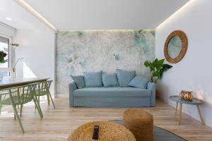 sala de estar con sofá azul y mesa en ACQUARELA Family Home free parking by Cadiz4Rentals, en Cádiz
