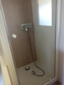 a shower with a glass door in a bathroom at camping les charmettes in Les Mathes