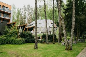 a house in the middle of a yard with trees at SPA VILNIUS Anykščiai in Anykščiai