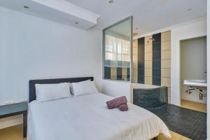 a bedroom with a large white bed and a sink at Inn & Out Sandton Park in Johannesburg
