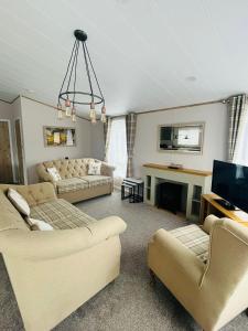 sala de estar con 2 sofás y TV en Eastgate Lodge with Hot Tub, en Malton